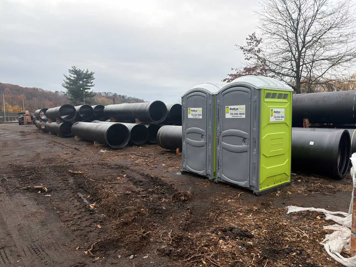 Several portable restroom units lined up on an active construction jobsite, illustrative stock photograph