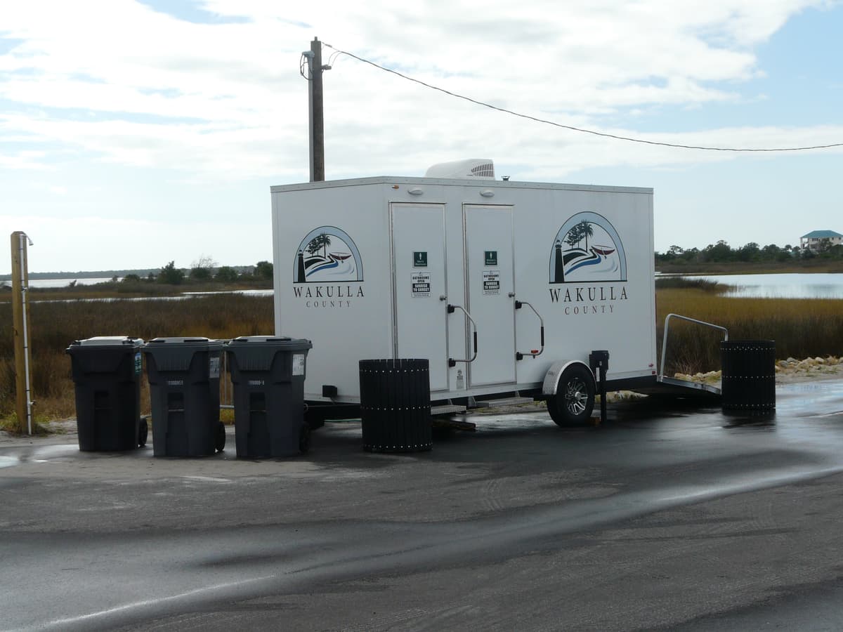 A towable restroom trailer parked at a Florida coastal park, illustrative stock photograph